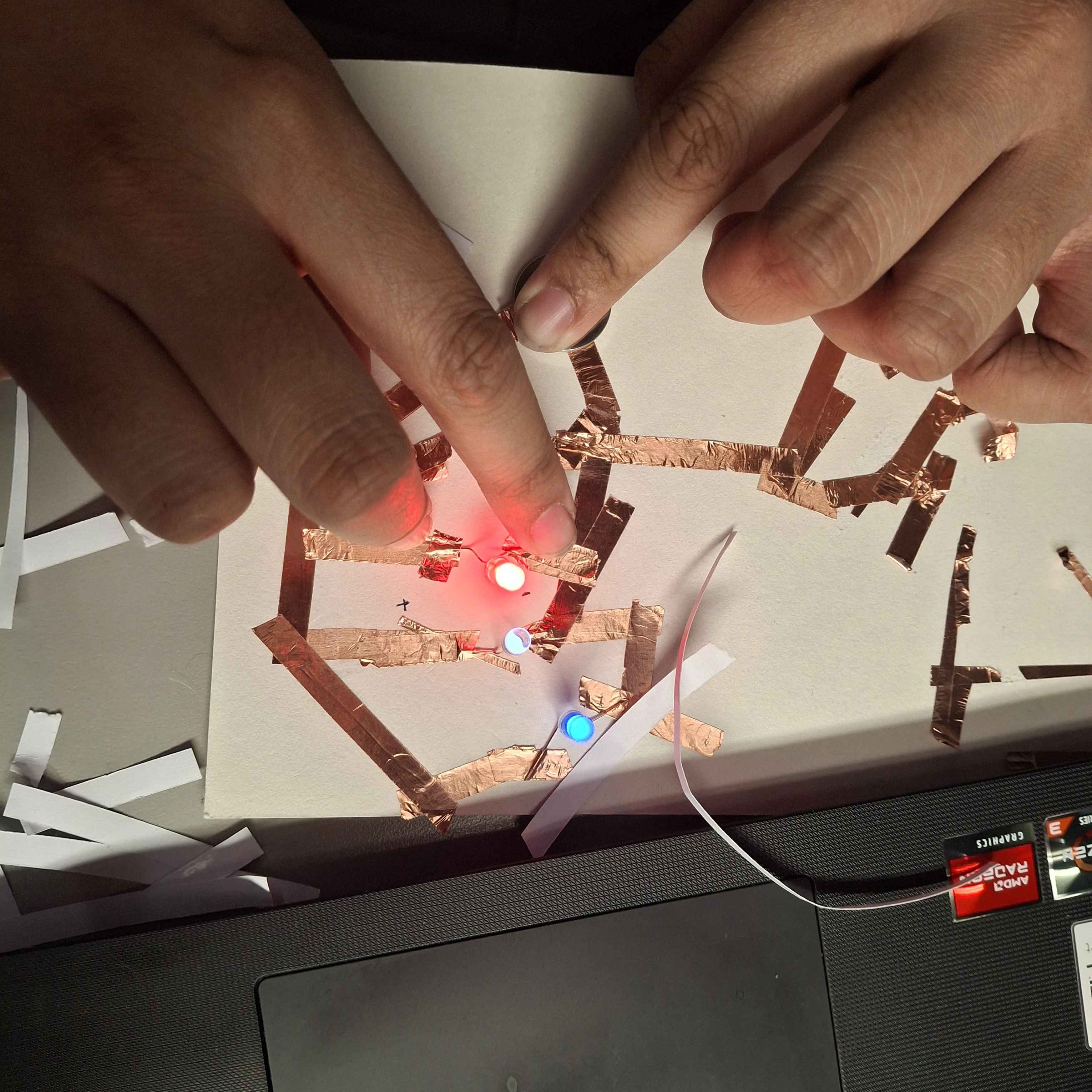 A bird's eye view of my circut operating as intended with the three lights turning on very brightly. But in order to make this parralel circut work, I Had to hold one of th LEDs in place, or having it in a specific position in order to light up